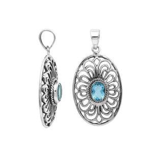 A handcrafted sterling silver pendant featuring a radiant Blue Topaz Quartz gemstone centered in an elegant Balinese filigree oval frame.
