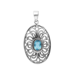 A handcrafted sterling silver pendant featuring a radiant Blue Topaz Quartz gemstone centered in an elegant Balinese filigree oval frame.