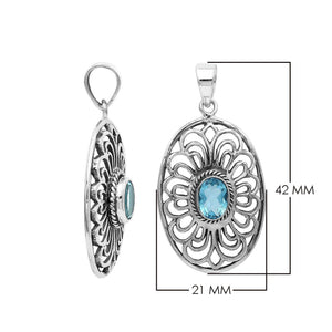 A handcrafted sterling silver pendant featuring a radiant Blue Topaz Quartz gemstone centered in an elegant Balinese filigree oval frame.