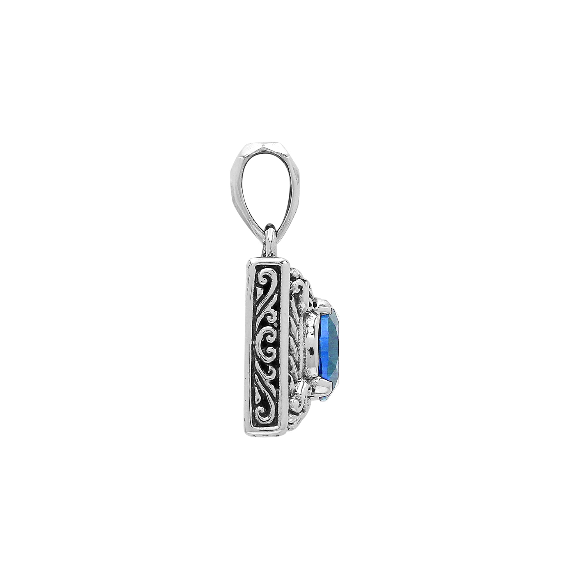 Rectangular sterling silver pendant featuring oval blue topaz quartz, swirl engravings, and smooth mirror-polished finish with detailed Balinese craftsmanship.