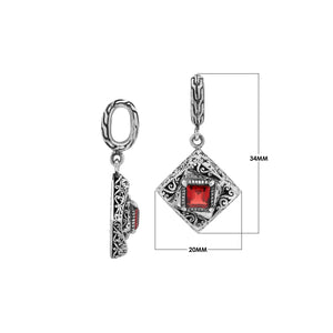 Diamond-shaped sterling silver pendant with red garnet quartz square centerpiece, filigree engravings, and polished finish in traditional Balinese design.