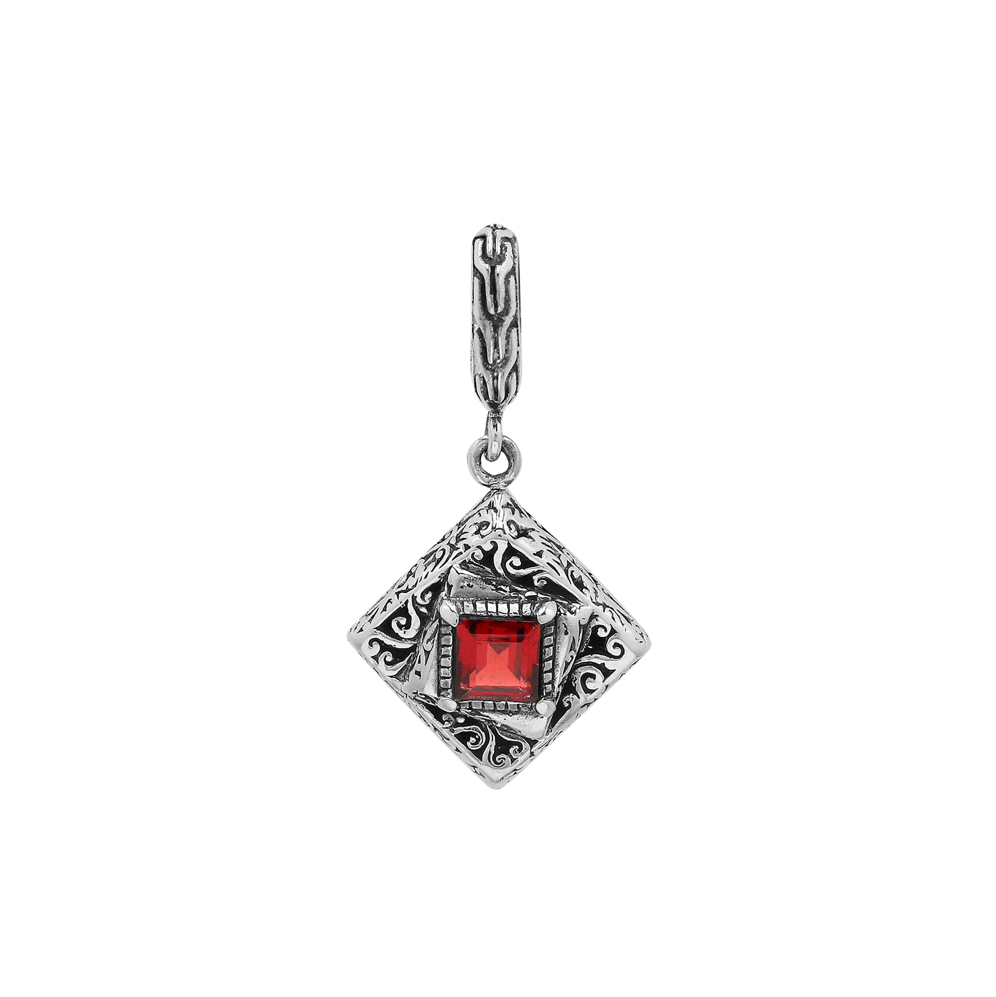 Diamond-shaped sterling silver pendant with red garnet quartz square centerpiece, filigree engravings, and polished finish in traditional Balinese design.
