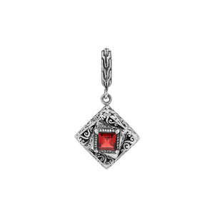 Diamond-shaped sterling silver pendant with red garnet quartz square centerpiece, filigree engravings, and polished finish in traditional Balinese design.
