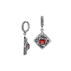 Diamond-shaped sterling silver pendant with red garnet quartz square centerpiece, filigree engravings, and polished finish in traditional Balinese design.