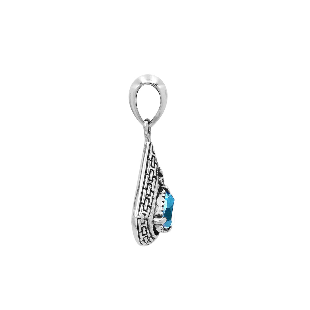 Triangular sterling silver pendant featuring trillion-cut blue topaz quartz with geometric engraving and polished Balinese finish.