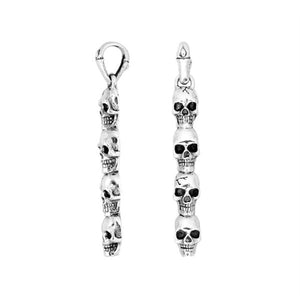 Sterling silver vertical skull pendant with carved detailing and polished finish.