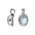 Sterling silver pendant featuring an oval Rainbow Moonstone set in a detailed Balinese carved frame with a polished glossy finish.