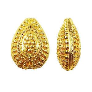 Handcrafted textured oval bead with 18K gold overlay over copper, featuring embossed dot patterns, made in India for wholesale jewelry production.