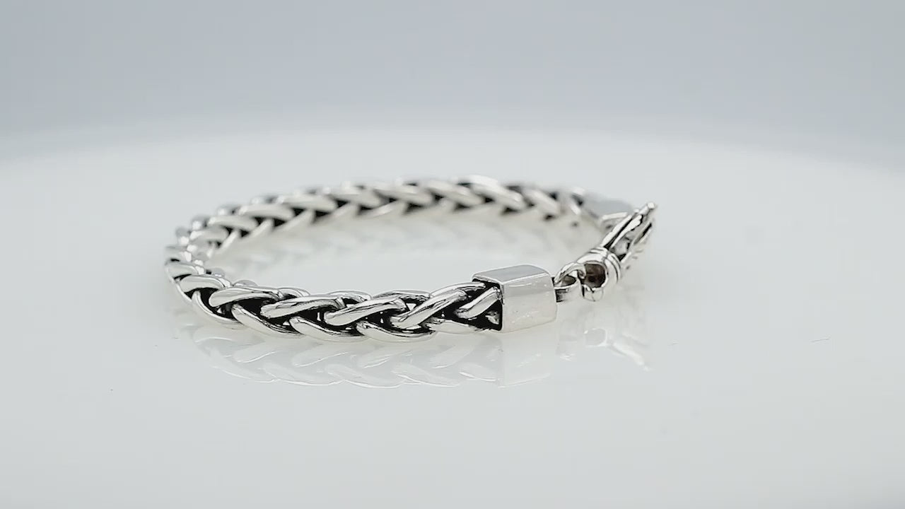 Wholesale sterling silver bracelet featuring a braided chain and decorative lobster clasp handcrafted in Bali.
