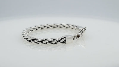 Wholesale sterling silver bracelet featuring a braided chain and decorative lobster clasp handcrafted in Bali.