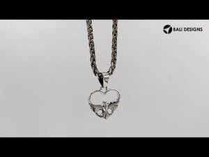 A handcrafted sterling silver heart and dove pendant featuring a minimalist design and a mirror-polished finish with Balinese artistry.