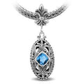 Sterling Silver Ornate Oval Pendant Featuring Blue Topaz Quartz With Fleur-De-Lis Decorative Bail.