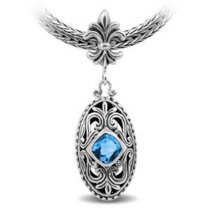 Sterling Silver Ornate Oval Pendant Featuring Blue Topaz Quartz With Fleur-De-Lis Decorative Bail.